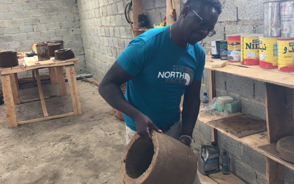 Maker shaping a clay stove in Ethiopia